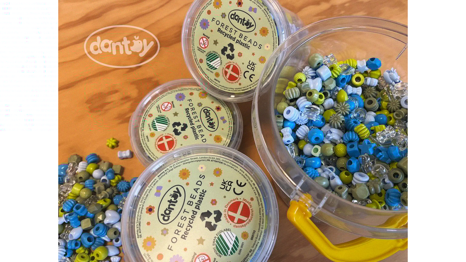 Gennemsigtige beholdere med blå og grønne perler på træbord